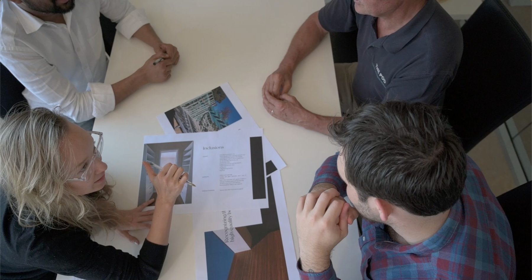 Jacqueline and team members reviewing plans and inclusions around a table